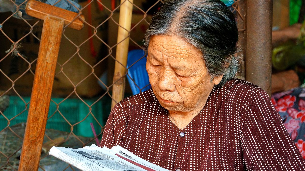 MUJER DE DANANG LEYENDO LA PRENSA