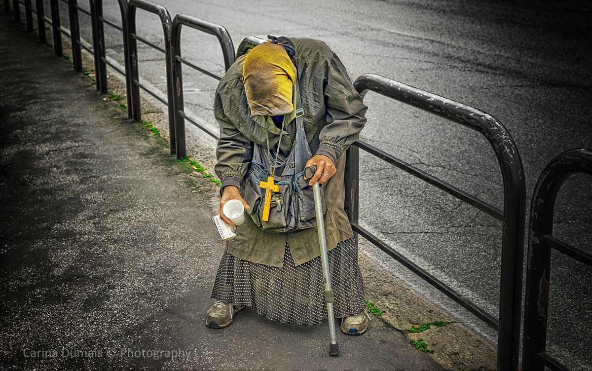 A gypsy dressed as an old woman. An attempt to deceive tourists to give money. You can see that she / he is not really old at the hands, they look much too young. But It provided a nice picture.